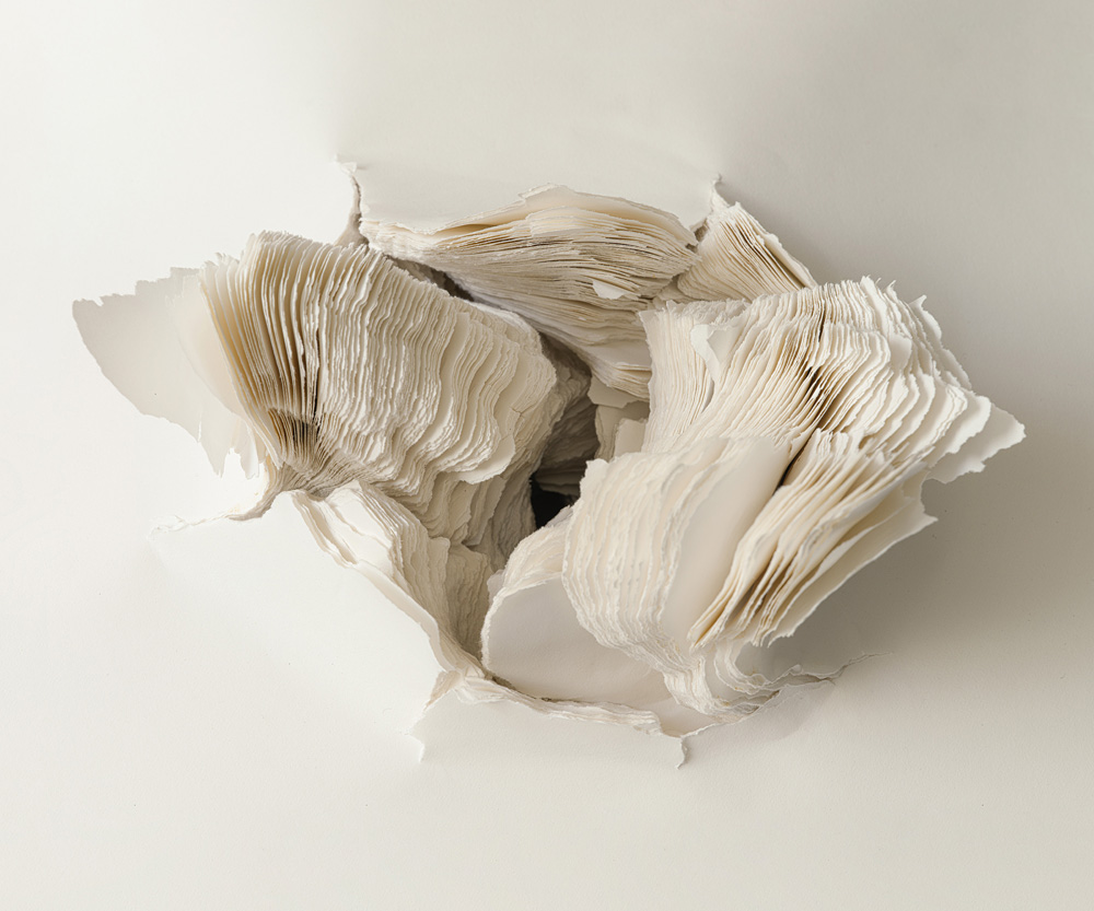 viele Lagen weißes Papier, in der Mitte aufgerissen